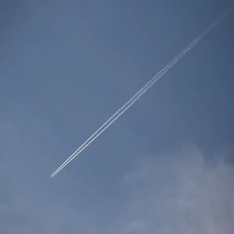 Una estela de condensación que se extiende diagonalmente a través de un cielo azul