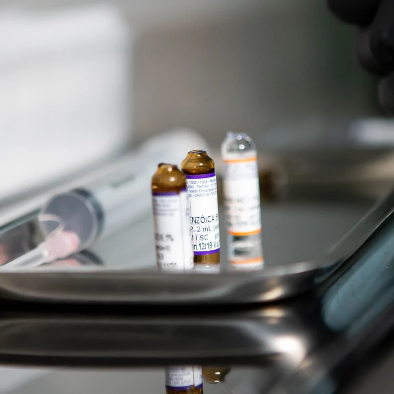 Drug ampoules and a syringe on a tray